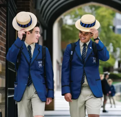 Two smiling students in school blazers